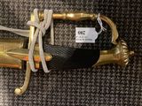 a gold sword with a black handle on a carpet