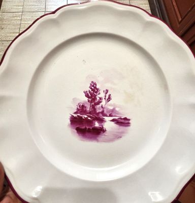 quelqu'un tient une assiette sur laquelle est représenté un homme dans un bateau