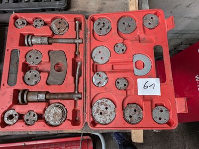 une mallette rouge contenant des outils, posée sur une table