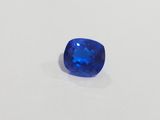 a blue sapphire stone on a white surface