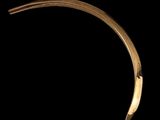 a close up of a gold bracelet on a black background