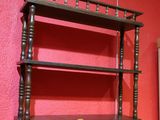 une étagère surmontée d'une tablette en bois