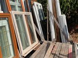 many windows sitting on a wooden deck outside of a house
