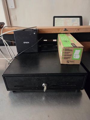 une boîte posée sur une caisse enregistreuse, elle-même posée sur un bureau