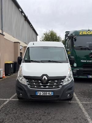 une camionnette blanche garée sur un parking à côté d'un bus vert
