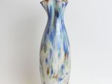 a blue and white vase sitting on a white surface