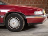 a red car parked in front of a brick wall