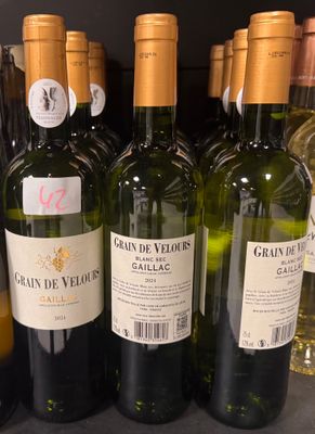 plusieurs bouteilles de vin sont alignées sur une étagère