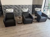 three chairs and a table in a room with a stone wall