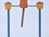 un petit jouet en bois représentant un homme sur une balançoire à bascule