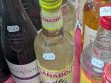 many bottles of alcohol on a table with a pink table cloth
