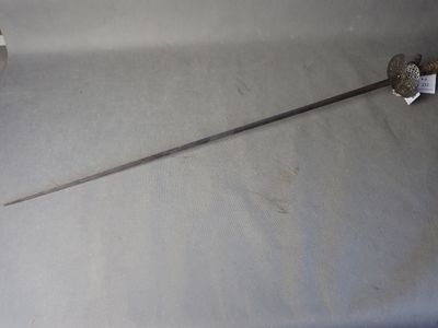 a sword that is sitting on a table next to a roll of toilet paper