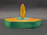 a yellow and green candle that is on top of a green base