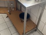 a small kitchen with a metal table and a sink