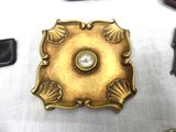 a gold plate with a diamond in it on a table