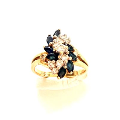 une photo d'une bague sertie d'un diamant et d'un saphir sur un fond blanc