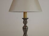une lampe posée sur une table, avec un abat-jour blanc
