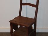 a small wooden chair sitting in front of a white wall
