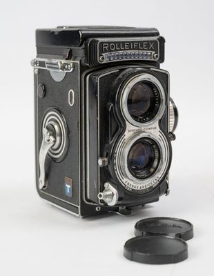 un vieil appareil photo avec un objectif, sur fond blanc