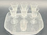 a tray with four glasses on it on a table