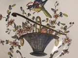a plate with a bird on it and flowers on it