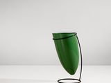 une lampe de table verte avec un fil noir posée sur une surface blanche