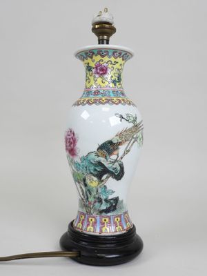 une image représentant une lampe posée sur une table, sur laquelle est perché un oiseau