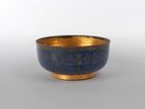 un bol ancien en laiton orné de motifs bleus et dorés