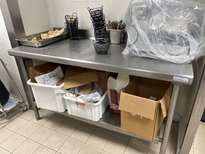 une grande table en inox sur laquelle sont posées plusieurs boîtes