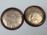 two silver coins sitting on top of a white table