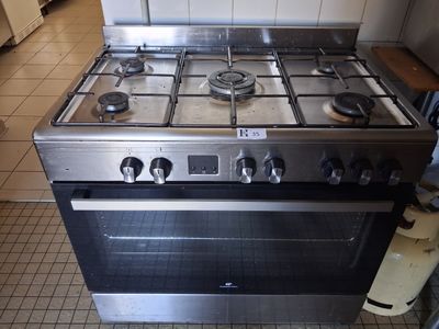a stainless steel stove in a kitchen with tile flooring