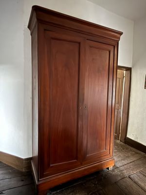 a large wooden armoire in the corner of a room