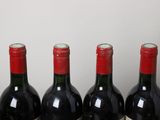 three bottles of red wine are lined up on a table