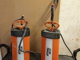 two orange and white sprayers sitting on a counter