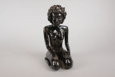 statue d'une femme assise à genoux sur un fond blanc