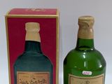 une bouteille d'alcool posée à côté d'une boîte sur une table