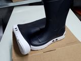 a pair of black rain boots sitting on top of a box