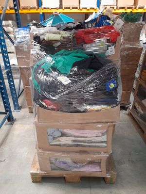 de nombreux cartons de vêtements posés sur une palette dans un entrepôt