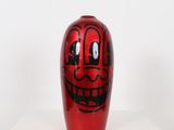 a red vase with a face painted on it