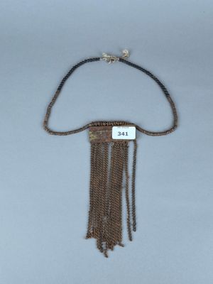 un vieux collier composé d'une chaîne et d'une pendentif