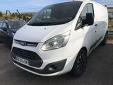 la camionnette blanche est garée dans le parking à côté d'autres voitures