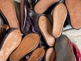 many pairs of shoes sitting in a pile on a bed