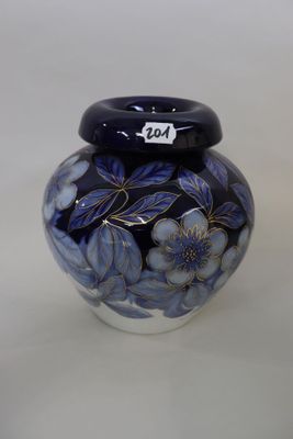 a blue and white vase with flowers painted on it