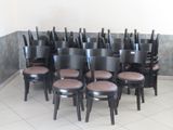 rows of black chairs in a room with a white tile floor