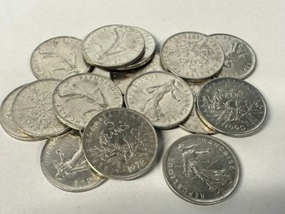 a pile of silver coins on a white surface