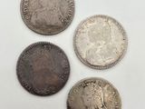 quatre types différents de pièces d'argent sur une surface blanche