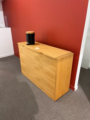 une photo d'une pièce avec un mur rouge et une armoire en bois