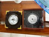 two clocks sitting on a shelf next to each other