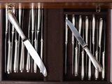 a wooden box with silverware in it and a knife in it