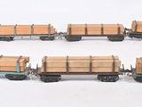 six caisses en bois posées sur un wagon, sur une surface blanche